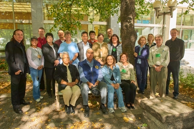 Dix-neuf personnes debout et assises sous un arbre.