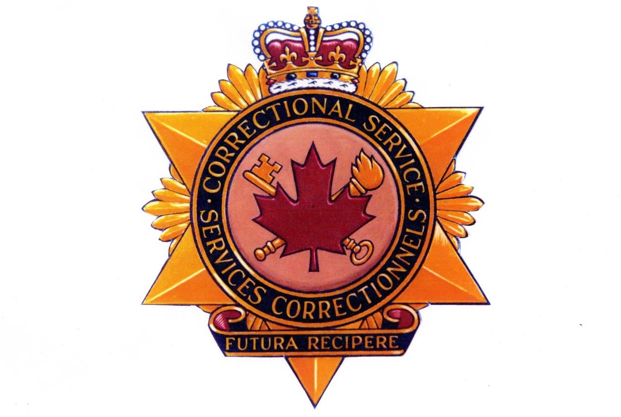 CSC badge with maple leaf in the middle, in front of a key and torch. Crown on top of badge, with text that reads Correctional Service Canada, Futura Recipere below.