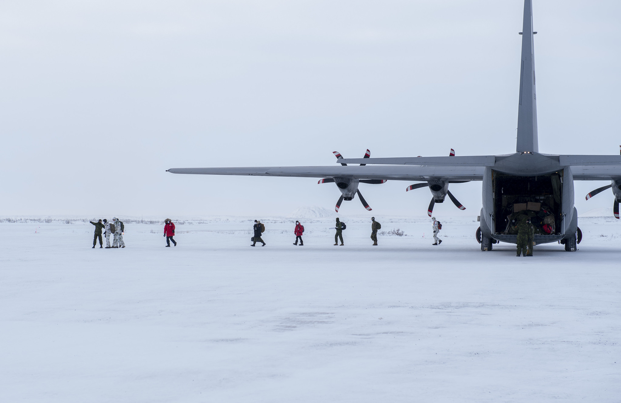 The Dive Task Force (DTF), comprised of dive units from Fleet Dive Unit (Atlantic) clearance divers, port inspection divers from various reserve units, combat divers from 4 Engineering Support Regiment, and French divers from 2nd Foreign Engineer Regiment, France, arrives in a CC-130J Hercules at Tuktoyaktuk, Northwest Territories on February 18, 2022 to take part in Operation NANOOK-NUNALIVUT 22.