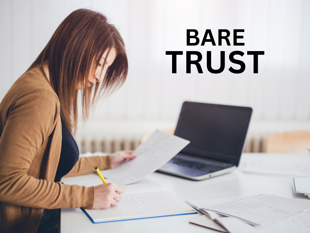 Woman writing on notebook with the words bare trust with a laptop in the background