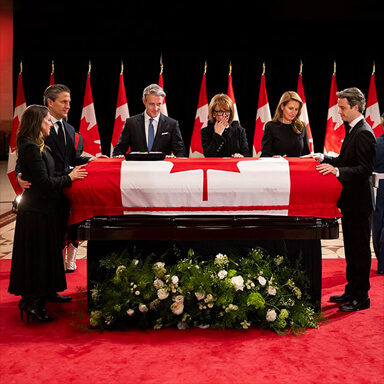 Family members stand around a flag-draped casket.
